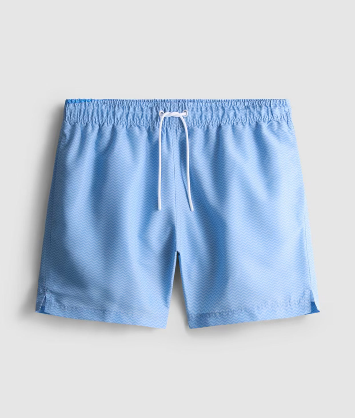 A pair of drawstring swimming shorts with a mesh lining and a zig-zag pattern