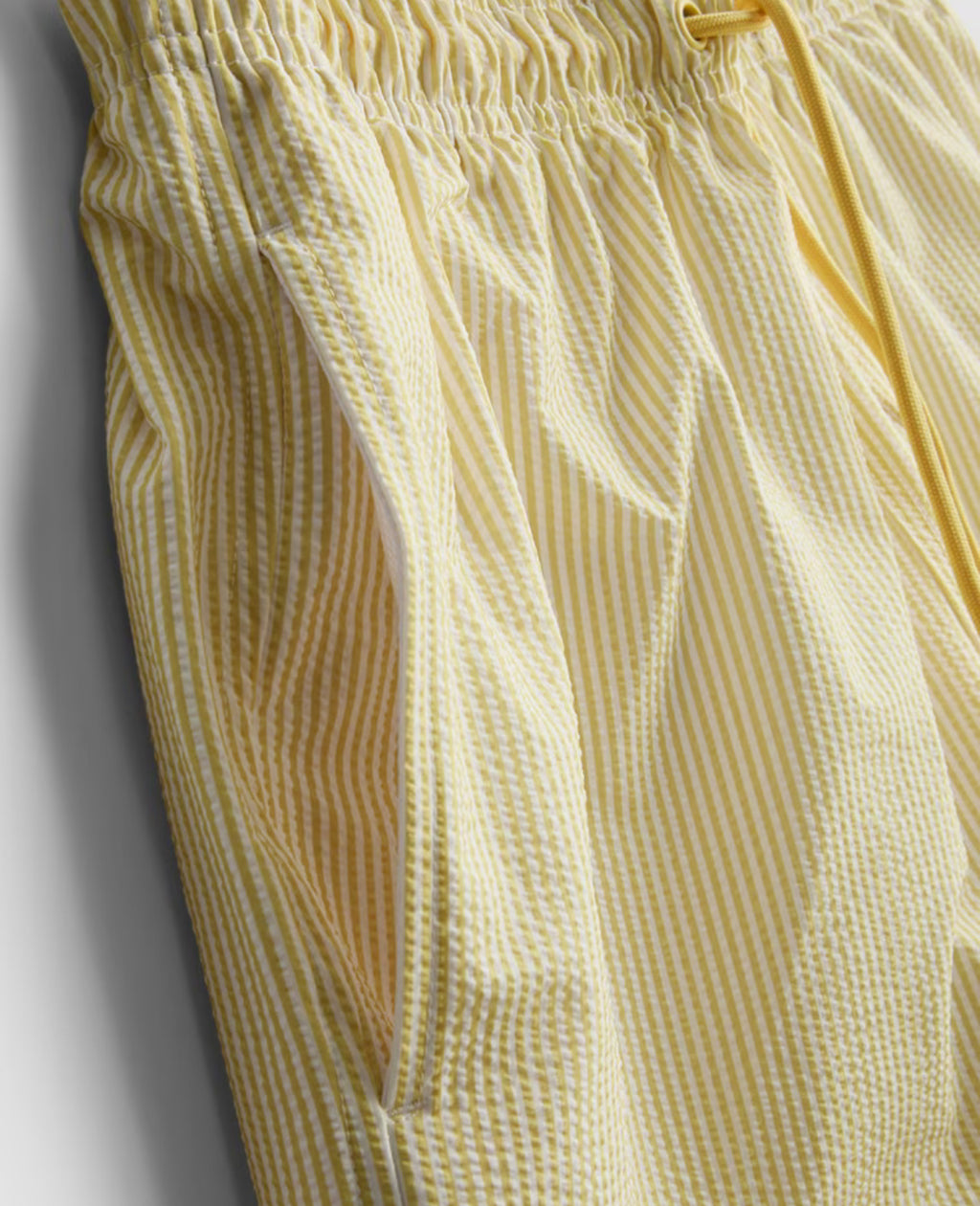 A pair of striped seersucker swimming shorts with a drawstring waistline, pockets, and mesh lining.