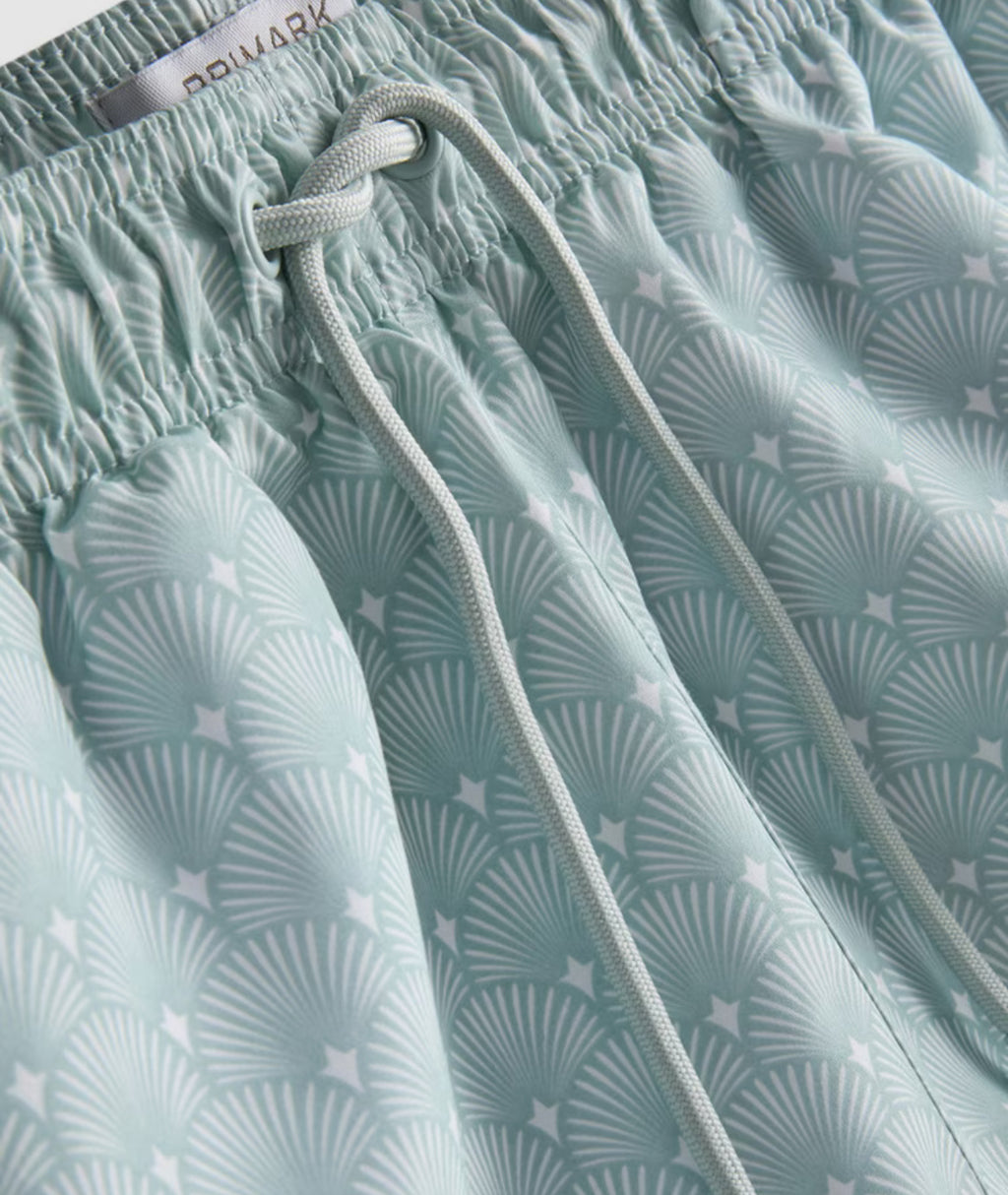 A pair of swimming shorts with mesh inner lining, drawstring waistline, and geometric fan design