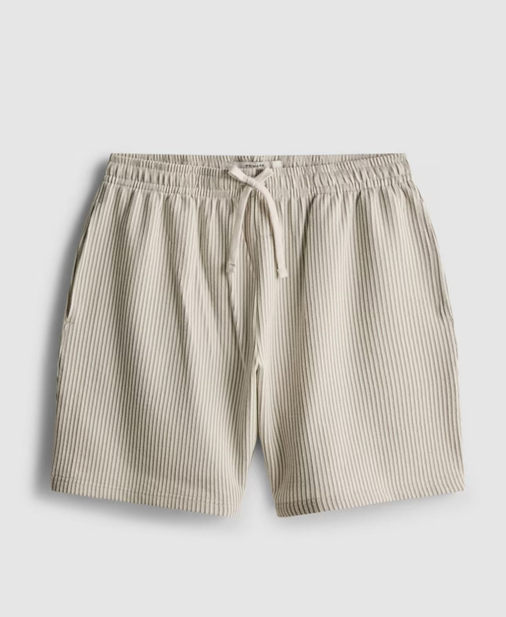 A pair of pyjama shorts with textured stripes, a drawstring waistline, and pockets