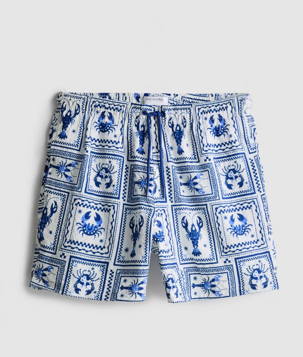 A pair of swimming shorts with a textured finish, drawstring, and mesh lining