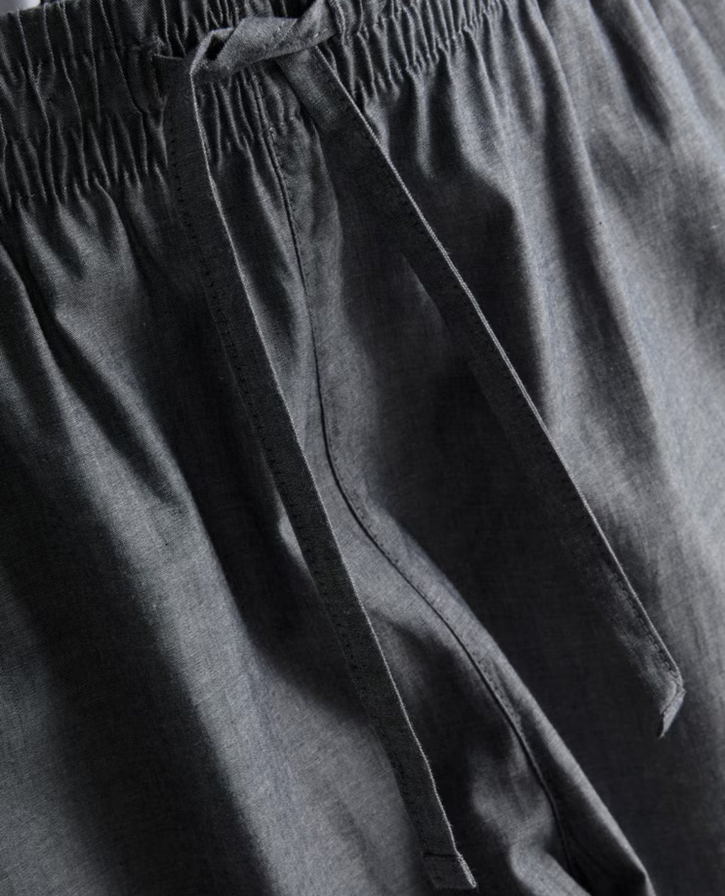Two pairs of pyjama bottoms with a drawstring waistline and a poplin texture