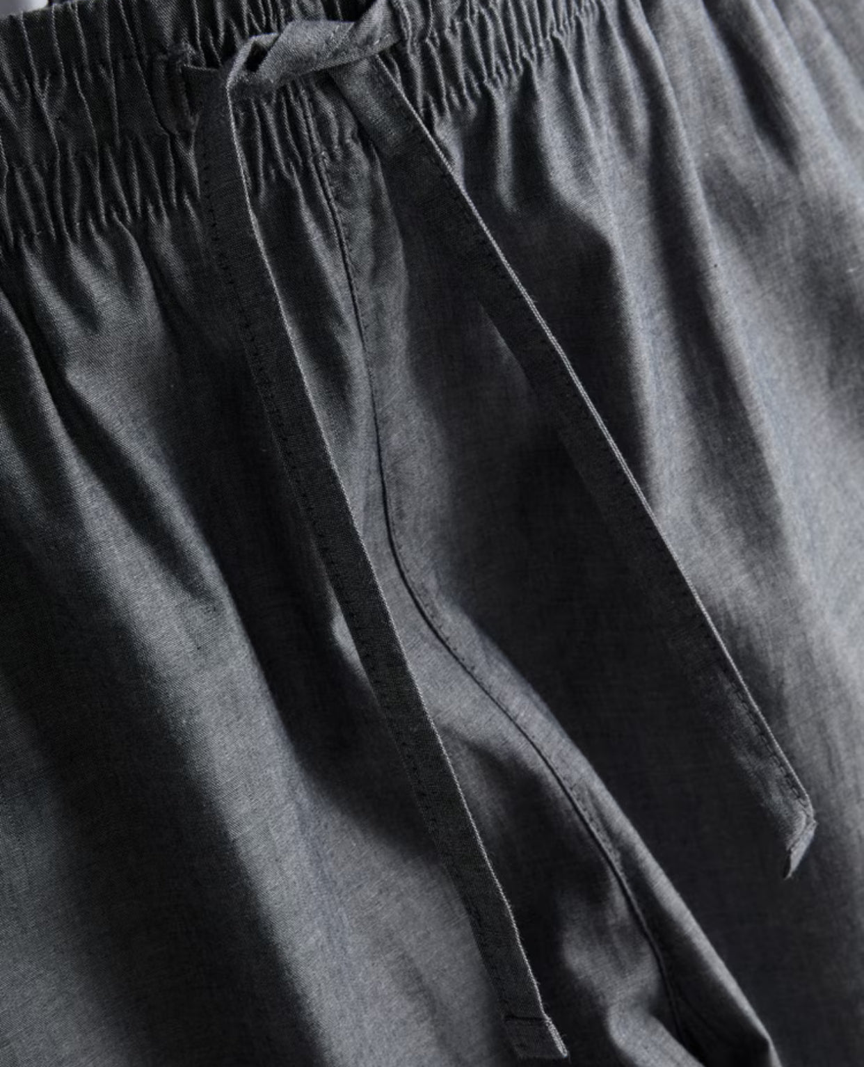 Two pairs of pyjama bottoms with a drawstring waistline and a poplin texture