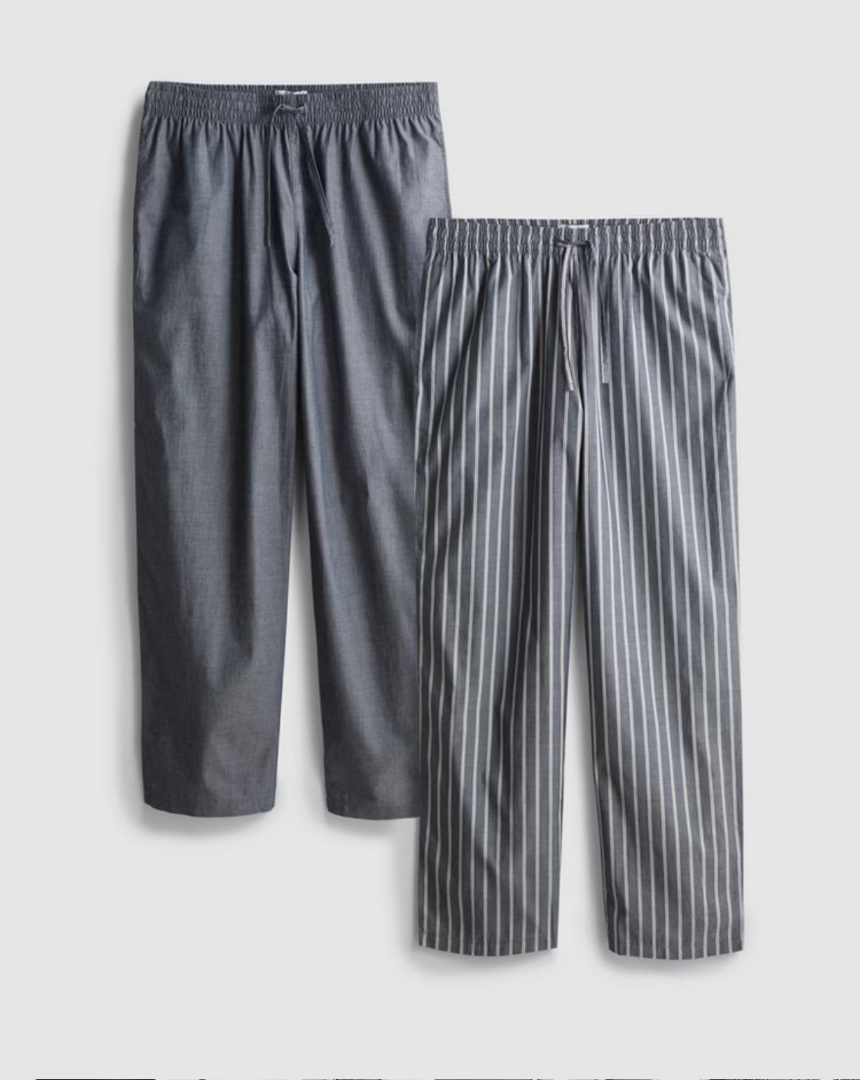 Two pairs of pyjama bottoms with a drawstring waistline and a poplin texture