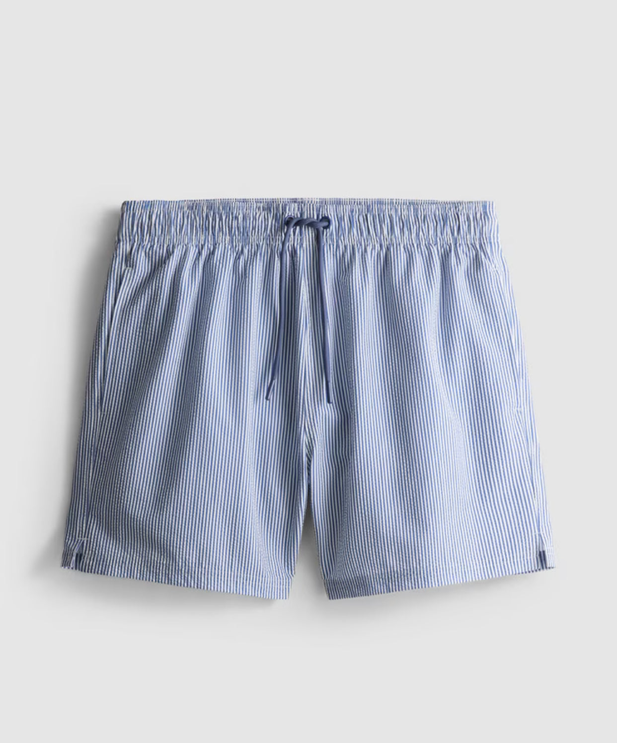 A pair of striped seersucker swimming shorts with a drawstring waistline, pockets, and mesh lining.
