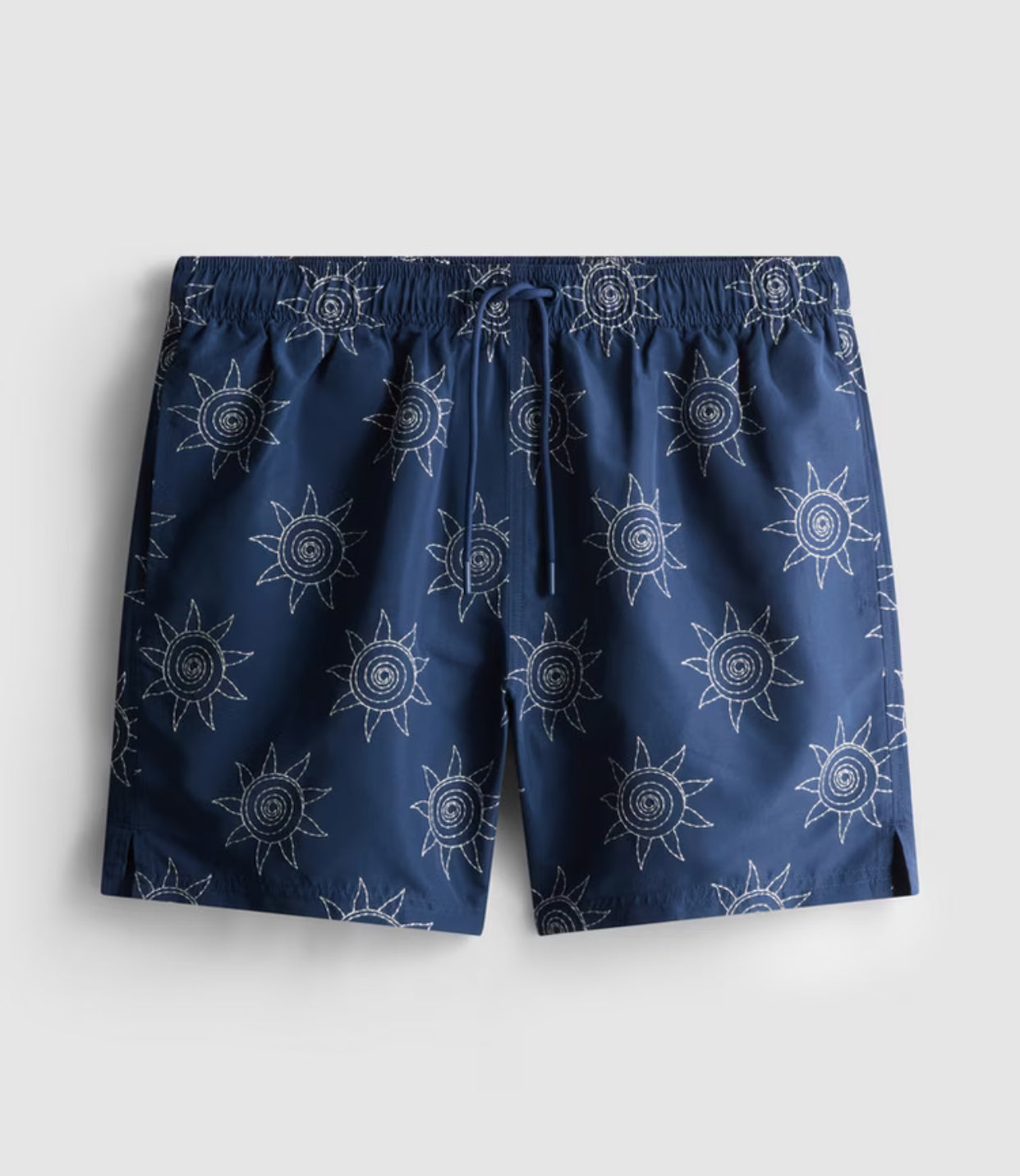 A pair of swimming shorts with embroidered sun design, mesh inner, and drawstring waistline