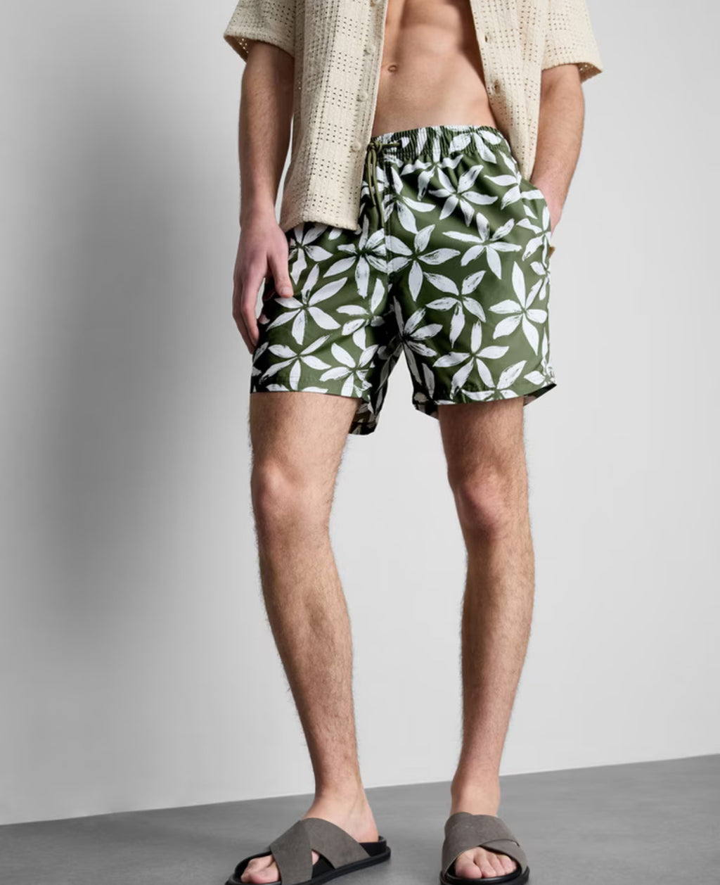 A pair of floral swimming shorts with drawstring waistline, pockets, and inner mesh lining
