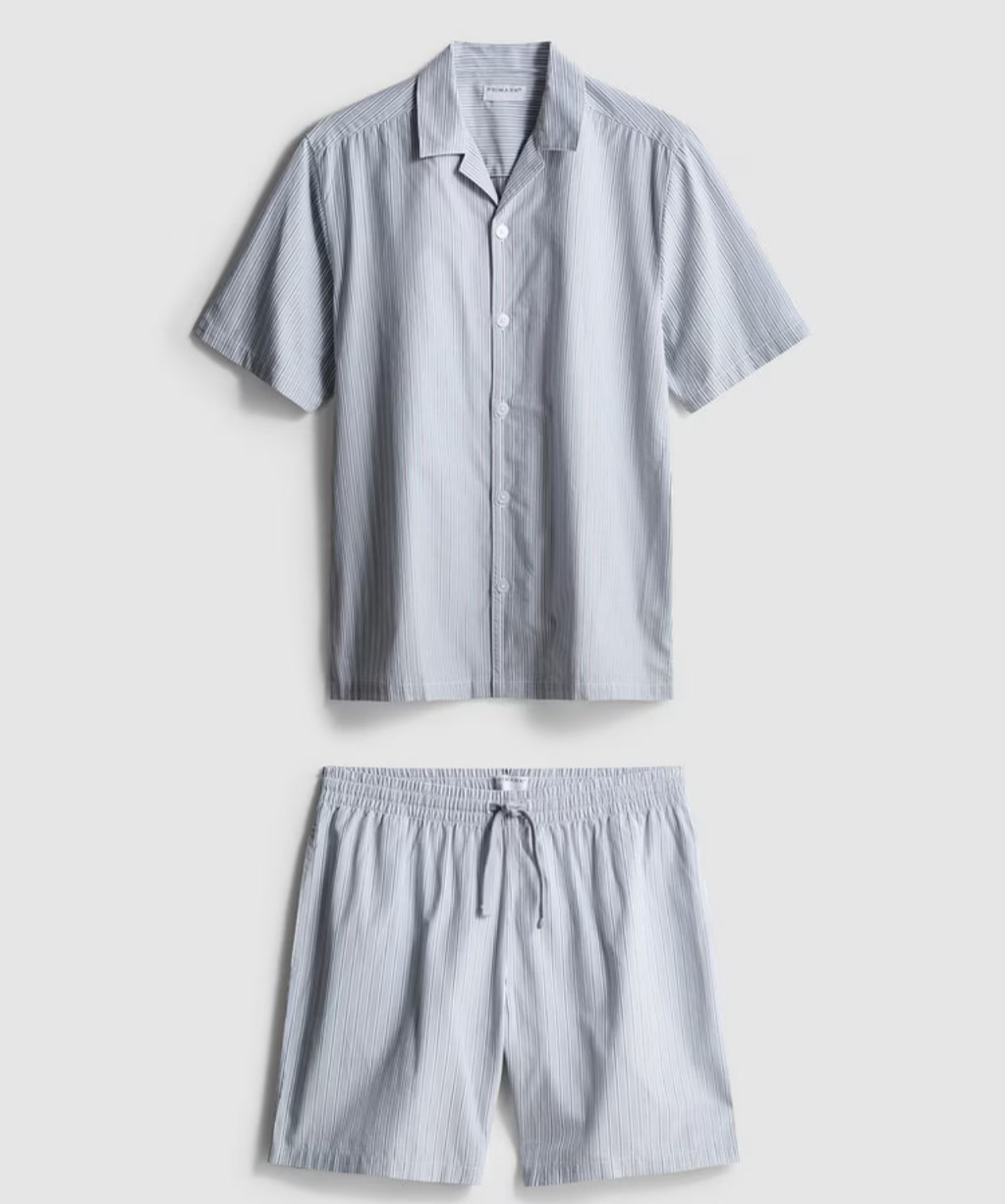 A pair of pyjamas with shorts and button up top